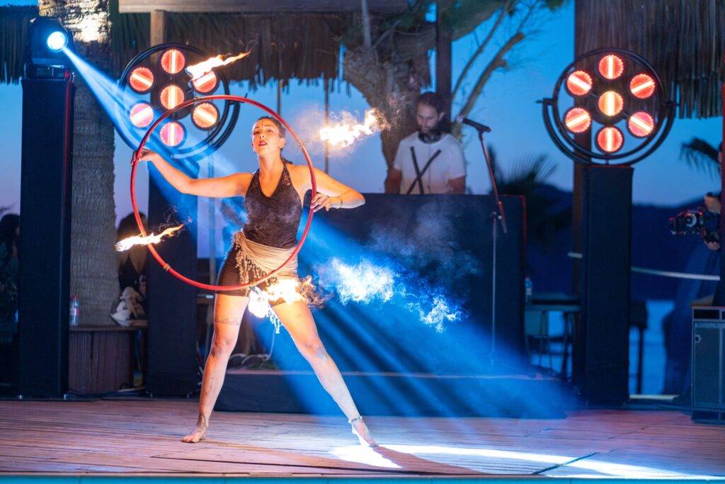 A picture of a corporate event showing a fire dancer in the foreground and beam moving heads and retro blinders in the background