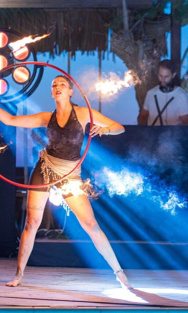 A picture of a corporate event showing a fire dancer in the foreground and beam moving heads and retro blinders in the background