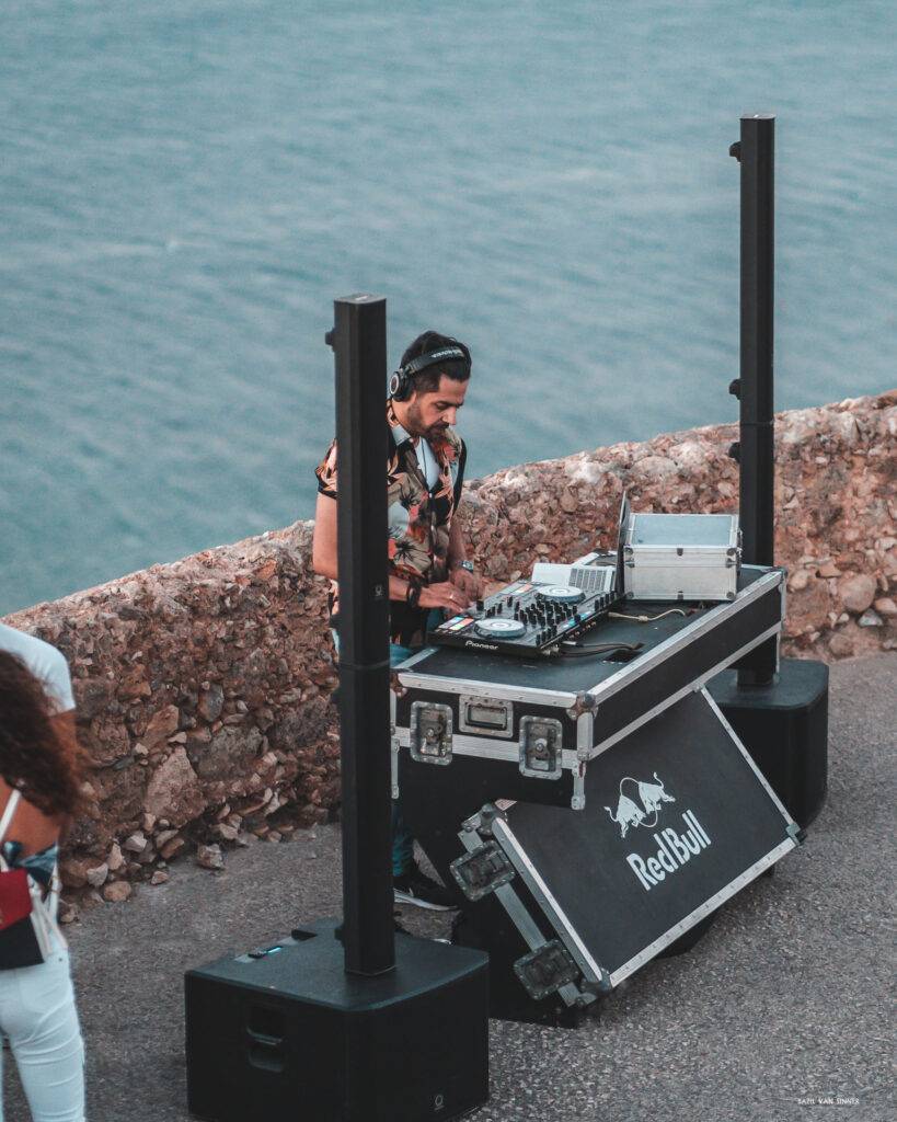 A picture of DJ MiAlpha performing at CastleFest Crete 2023, surrounded by Turbosound IP3000 speakers